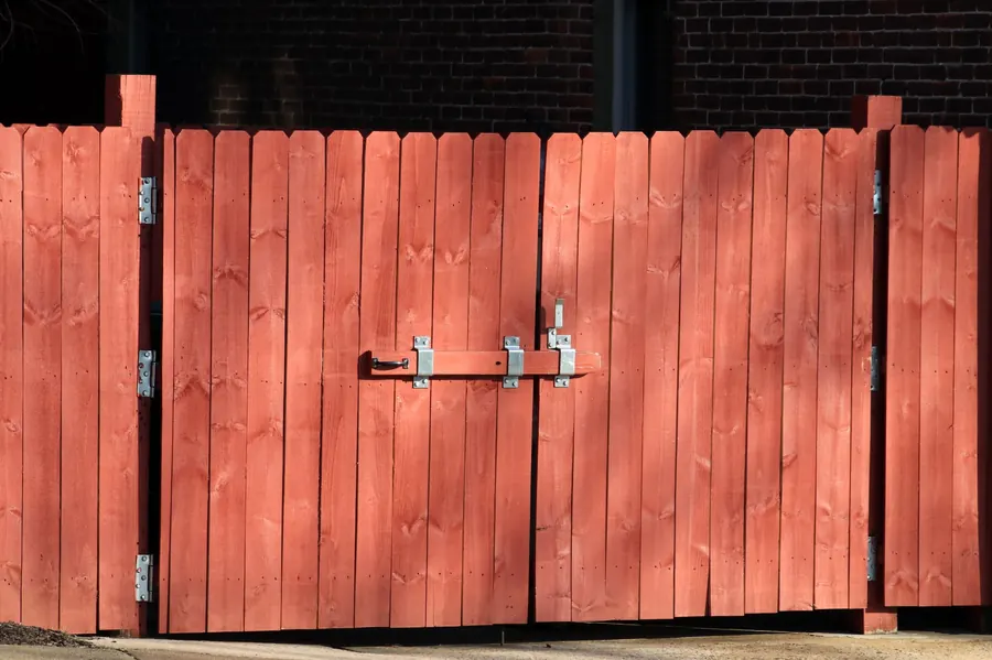 Red stained wooden fence gate