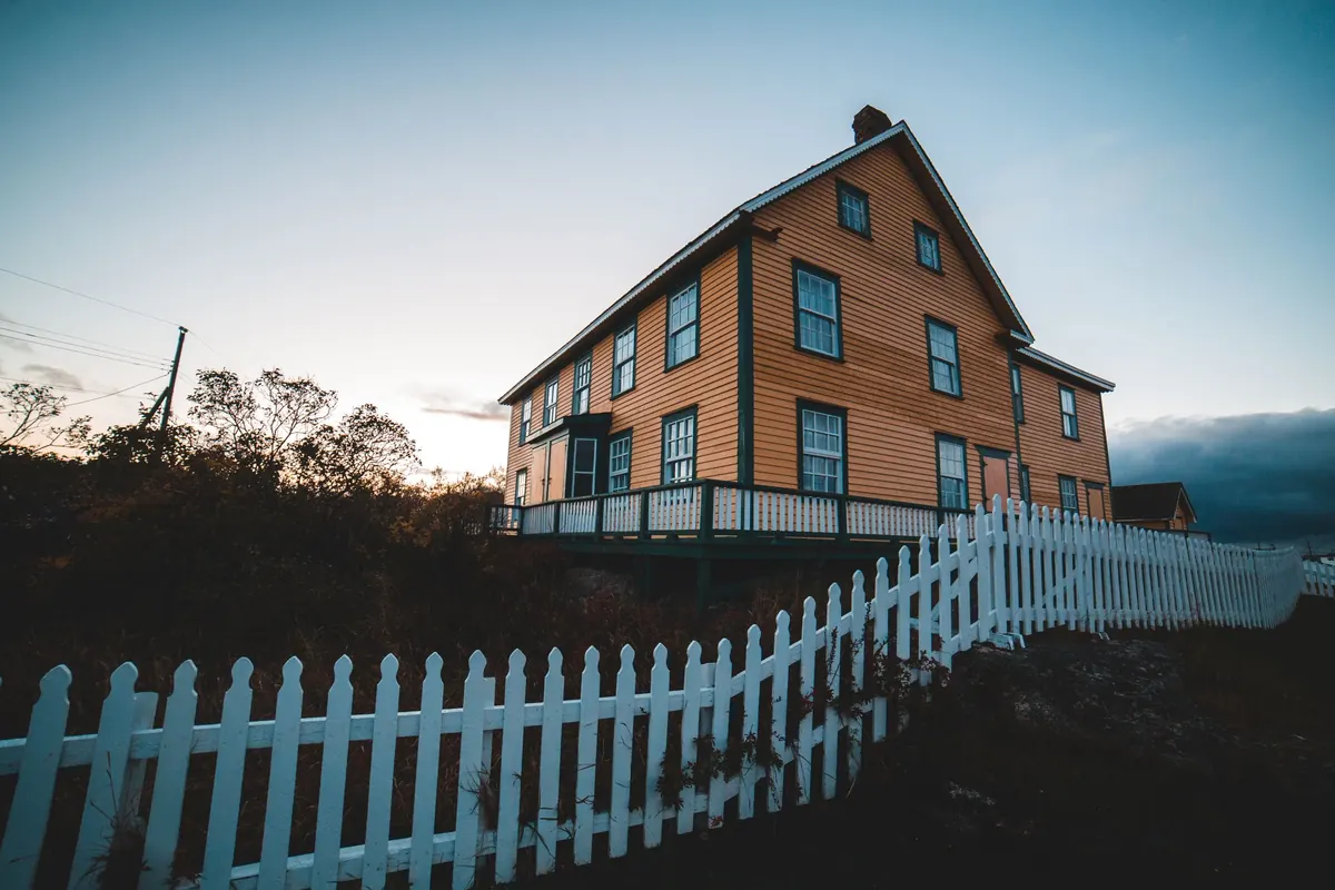House with a white picket fence at sunset