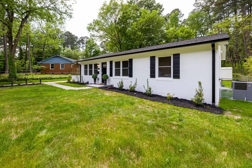 Freshly painted white single-story house with a green lawn